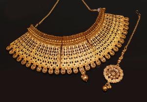A beautiful golden necklace with stone and diamonds on dark black background.jpg